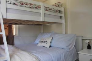 a bedroom with a bunk bed with a pillow on it at Little Ray on Sunshine. Hamptons style beachhouse in Woorim