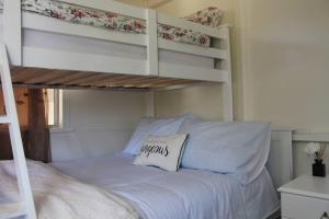 a bedroom with a bunk bed with a pillow on it at Little Ray on Sunshine. Hamptons style beachhouse in Woorim +23 photos