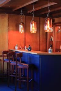 a bar with chairs and a blue counter with lights at Hotel Askania 1927 in Bad Wiessee