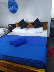 a bedroom with two beds with blue sheets and pillows at Himansa Homestay in Ella