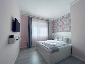 sypialnia z dużym łóżkiem i oknem w obiekcie Thermal Family w mieście Makó