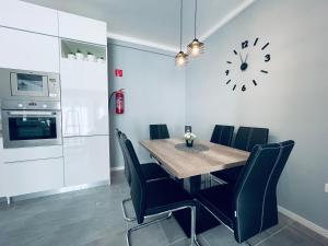 jadalnia ze stołem, krzesłami i zegarem w obiekcie Thermal Family w mieście Makó