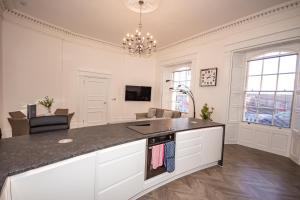 a kitchen with a counter top and a living room at The Kensington Suite in Plymouth