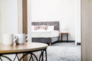 a bedroom with a bed and a table with a coffee cup at Stara Kuźnia in Łuków