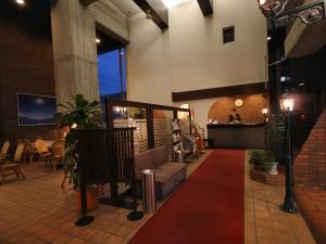 盛岡市にある北 ホテル の赤いカーペットとテーブルと椅子が備わるレストラン