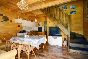 een eetkamer met een tafel en stoelen en een trap bij Domek Twórczy Kąt in Święta Katarzyna