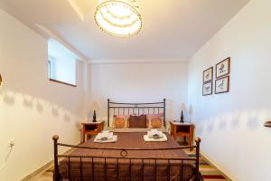 a bedroom with a bed and a chandelier at Archontiko Mainalou in Vytina