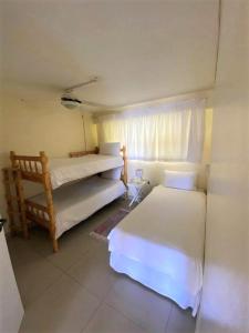 a bedroom with two beds and a window at Cozumel 311 in Umdloti