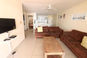 a living room with two brown couches and a table at Cozumel 311 in Umdloti
