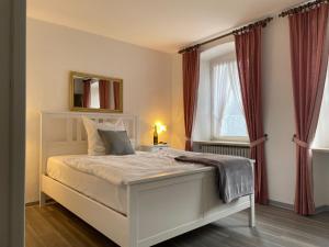 RATSKELLER Hotel & Restaurant في كروف: غرفة نوم بسرير ابيض ونافذة