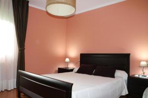 リャネスにあるApartamentos Rurales Andreaのベッドルーム1室(オレンジ色の壁の大型ベッド1台付)