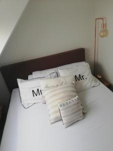 Una cama blanca con cuatro almohadas. en Crèmebol, en Nieuwpoort 17 fotos más