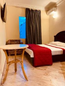 a bedroom with a table and a bed and a table and chair at SINGAPOUR MAROC in Casablanca