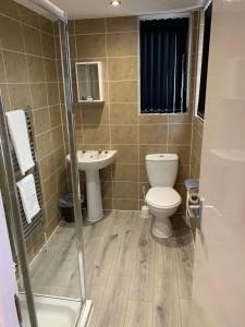 a bathroom with a toilet and a sink at 3 bed bungalow Waterloo by Pureserviced in Plymouth