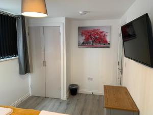 a bedroom with a bed and a television on the wall at 3 bed bungalow Waterloo by Pureserviced in Plymouth