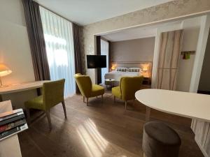 una camera d'albergo con un letto, un tavolo e delle sedie di PLATZHIRSCH ZÜRICH - Downtown Boutique Hotel & Sushi Lounge a Zurigo