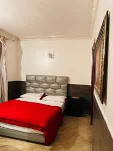 a bedroom with a large bed with a red blanket at SINGAPOUR MAROC in Casablanca