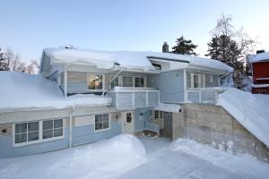 una casa está cubierta de nieve en Kuukkeli Apartments, en Saariselkä