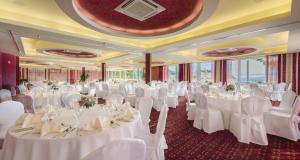 a banquet hall with white tables and chairs at Hotel Zora in Primošten