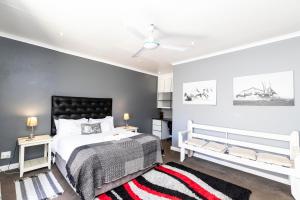 a bedroom with a bed, a desk and a painting on the wall at Fish Eagle Manor in East London