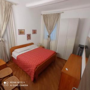 um quarto com uma cama com um edredão vermelho em Domus Sottoripa em Gênova