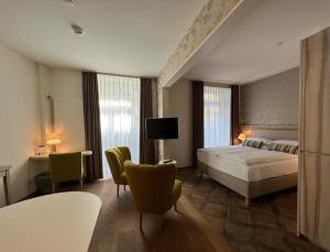 una camera da letto con un letto, un tavolo e delle sedie di PLATZHIRSCH ZÜRICH - Downtown Boutique Hotel & Sushi Lounge a Zurigo