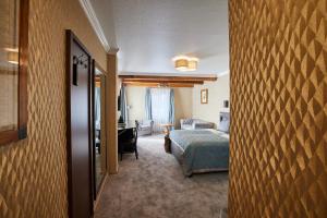 a hotel room with a bed and a desk at Atlas Posthotel in Garmisch-Partenkirchen