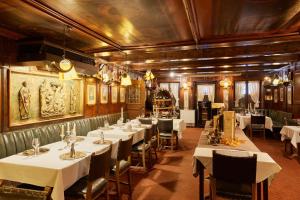 a dining room with white tables and chairs at Atlas Posthotel in Garmisch-Partenkirchen