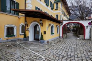 ein gelbes Gebäude mit einem Torbogen neben einer Straße in der Unterkunft Atlas Posthotel in Garmisch-Partenkirchen