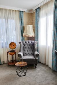 ein Wohnzimmer mit einem Stuhl und einem Tisch in der Unterkunft Atlas Posthotel in Garmisch-Partenkirchen