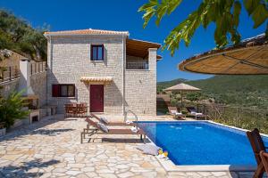 a villa with a swimming pool and a house at Athina Villas in Mikros Gialos
