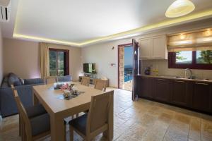 a kitchen and living room with a table and a couch at Athina Villas in Mikros Gialos