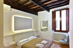 a bedroom with a bed and a window and a chair at Elite Rome apartments 2 in Rome