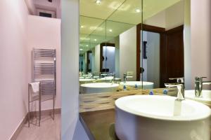 a bathroom with a row of sinks and mirrors at Elite Rome apartments 2 in Rome +28 photos