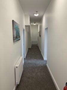 a long hallway with white walls and a hallway with a hallway at Kings Cross by Pureserviced in Plymouth
