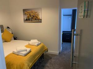 1 dormitorio con 1 cama con toallas en Kings Cross by Pureserviced en Plymouth