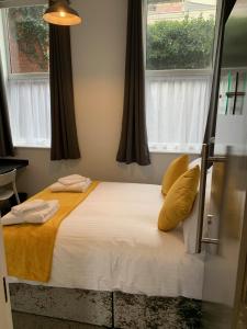 a bed in a room with two windows at Kings Cross by Pureserviced in Plymouth