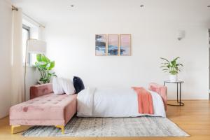 a bedroom with a pink bed and a pink couch at Riverside Two Bedroom Apartment in Canary Wharf in London
