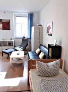 ein Wohnzimmer mit einem Sofa und einem Tisch in der Unterkunft Citywohnung Altstadt in Halle an der Saale