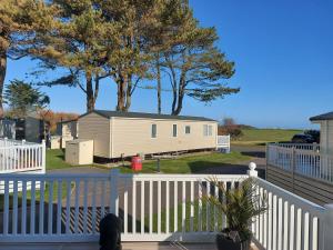 a house on a deck with a fence and trees at Springfield B6 in Brixham