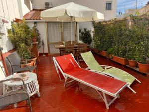 un patio con sillas, una mesa y una sombrilla en La Terraza, en Vinarós