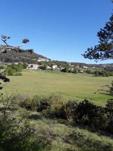 zielone pole z domem na wzgórzu w obiekcie Gite les Cigales w mieście Châteauvieux