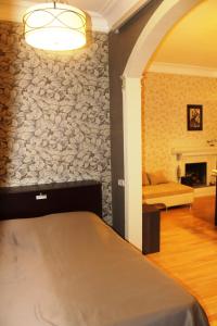 a bedroom with a bed and a stone wall at Vachnadze Apartment in Tbilisi City