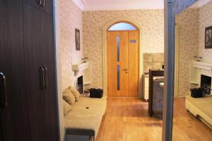 a hallway with a door and a living room with a couch at Vachnadze Apartment in Tbilisi City