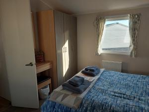 Un dormitorio con una cama con toallas azules. en Springfield B6, en Brixham