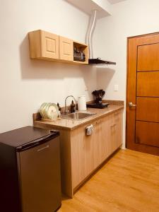 a small kitchen with a sink and a refrigerator at Mesatierra Garden Residences in Davao City