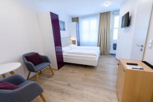una camera d'albergo con letto, tavolo e sedie di Hotel Garni Viktoria a Lindau