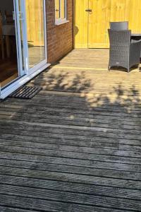 a porch with two chairs and a yellow door at Orchard Cottage in Tiverton