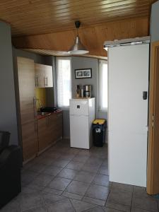 a kitchen with a white refrigerator and a ceiling at Szigeti Apartmanház in Pécs