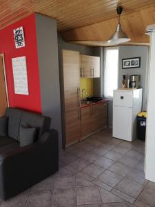 a kitchen with a couch and a refrigerator in a room at Szigeti Apartmanház in Pécs